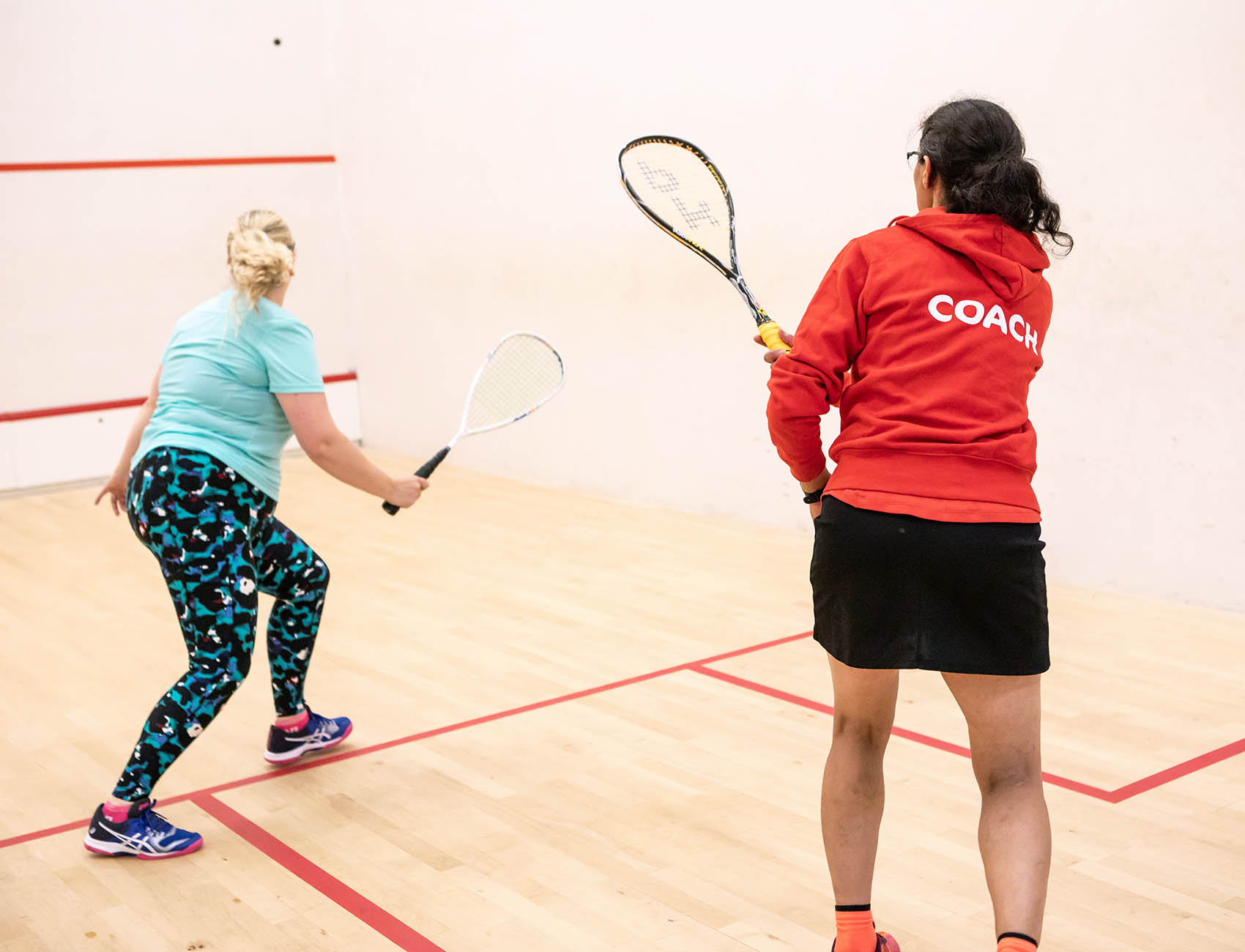 A squash player and coach on court